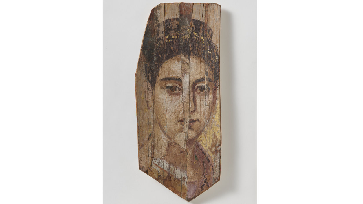 BLICK AUS DEM JENSEITS [Mumienporträt einer Frau (Inv. 1766), um 150 n. Chr., aus Fayum, Ägypten] Unter dem Begriff «Mumienporträts» versteht man die Gattung auf Holz gemalter Tafelporträts, die im kaiserzeitlichen Ägypten anstelle einer Totenmaske auf die mumifizierten Leichen eingebunden wurden. Sie gehören zu den wenig überlieferten Beispielen von Tafelmalereien aus der Antike. Die Archäologische Sammlung besitzt 14 Exemplare davon aus dem Fayum-Gebiet – einer Oase, die 80 km südwestlich von Kairo liegt. Die kaiserzeitlichen Mumienporträts finden ihren Ursprung in der altägyptischen Tradition der Mumienmasken. Durch die Vermischung der Kulturen, die mit der Ptolemäerherrschaft in Ägypten ihren Anfang nahm, fand eine Umdeutung der ägyptischen Sitten und ein Synkretismus der Religionen statt. Unter römischer Herrschaft wurde mit diesem Hintergrund die idealisierte altägyptische Mumienmaske zur individualisierenden Abbildung des Verstorbenen. Auch die mit der Maske eng verbundenen Jenseitsvorstellungen der ägyptischen Religion verloren weitgehend an Bedeutung. Vielmehr konzentrierte sich der neu entstandene Totenkult auf das Diesseits, in dem die Mumie mit dem Porträt zu einem Individuum wurde und so auch den kommemorativen Aspekt förderte – ähnlich wie bei den Fotos der Verstorbenen in den heutigen Grabstätten. Analysen haben gezeigt, dass die Korrespondenz zwischen Porträt und Leiche – in den wenigen vorhandenen Fällen, in denen das Mumienbildnis mit dem dazugehörigen Sarg erhalten geblieben ist – nicht immer übereinstimmend ist. Der Grund dafür ist noch Bestandteil aktueller Forschung. Die Mumienporträts der Archäologischen Sammlung bieten dem Besucher nicht nur ein vielfältiges Ensemble der Gattung und damit der antiken Malerei, sie weiten auch den Blick auf traurige neuzeitliche Ereignisse. Zwei Mumienporträts, die einst in der Sammlung waren, konnten 2016 den Rechtsnachfolgern des Berliner Verlegers Rudolf Mosse (1843–1920) restituiert werden. Die beiden Objekte wurden der Tochter und dem Schwiegersohn von Rudolf Mosse, dem Ehepaar Erna Felicia und Hans Lachmann-Mosse, kurz nach der nationalsozialistischen Machtübernahme in Deutschland 1933 widerrechtlich entzogen. Lesen Sie mehr dazu in der Medienmitteilung der Universität Zürich.